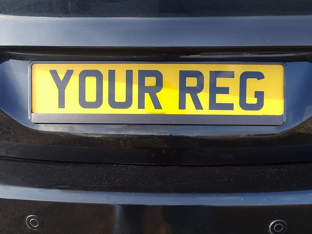 Yellow license plate with 'YOUR REG' text on a black car bumper.