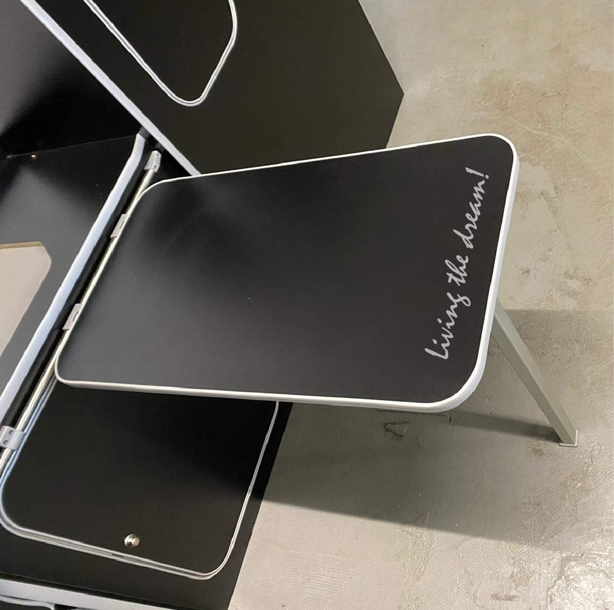 Black tray with 'Living the dream!' text on a concrete floor