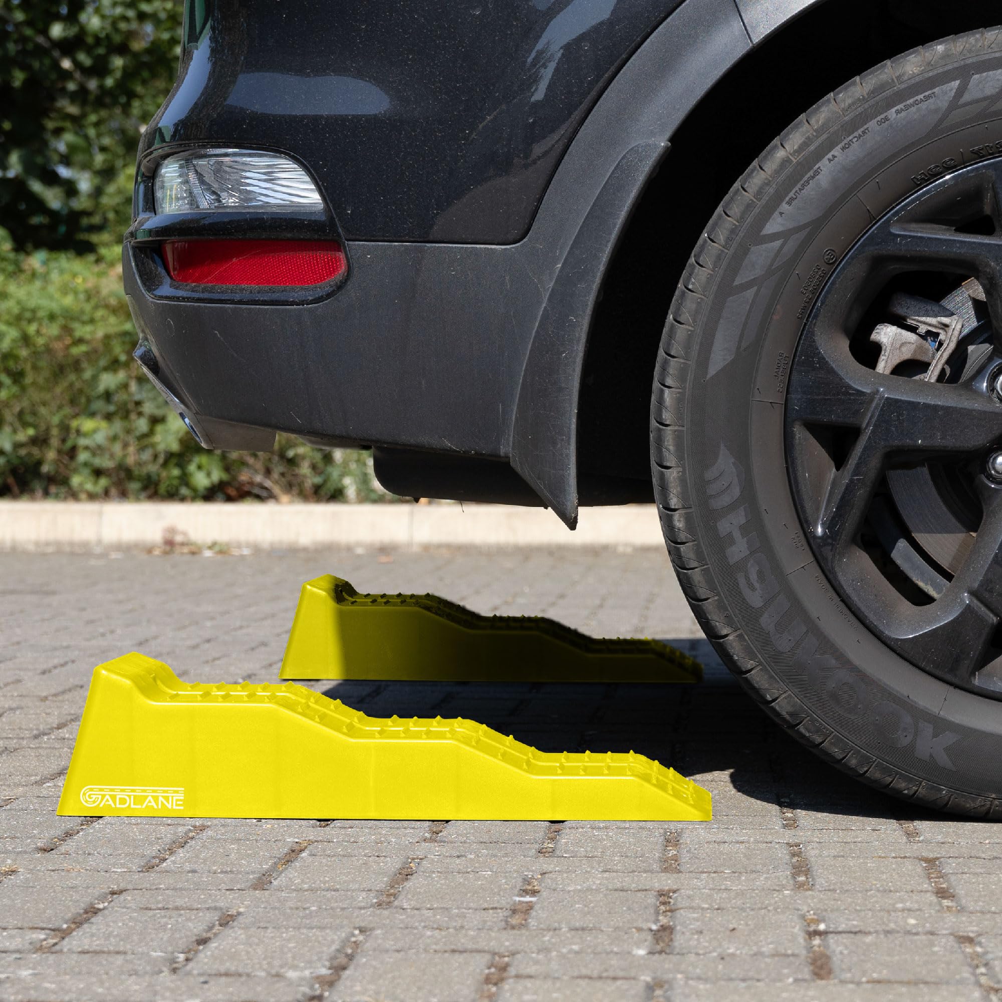 Black car with a yellow car stopper on a paved surface