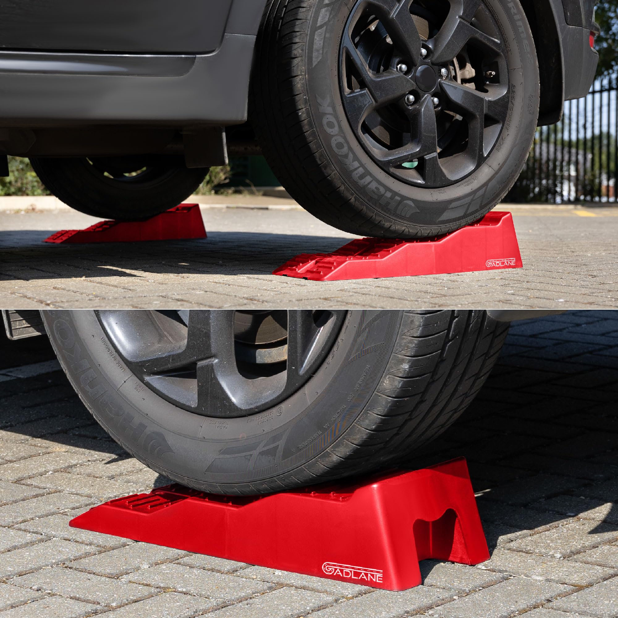 Red car jack stands supporting a vehicle on a driveway.