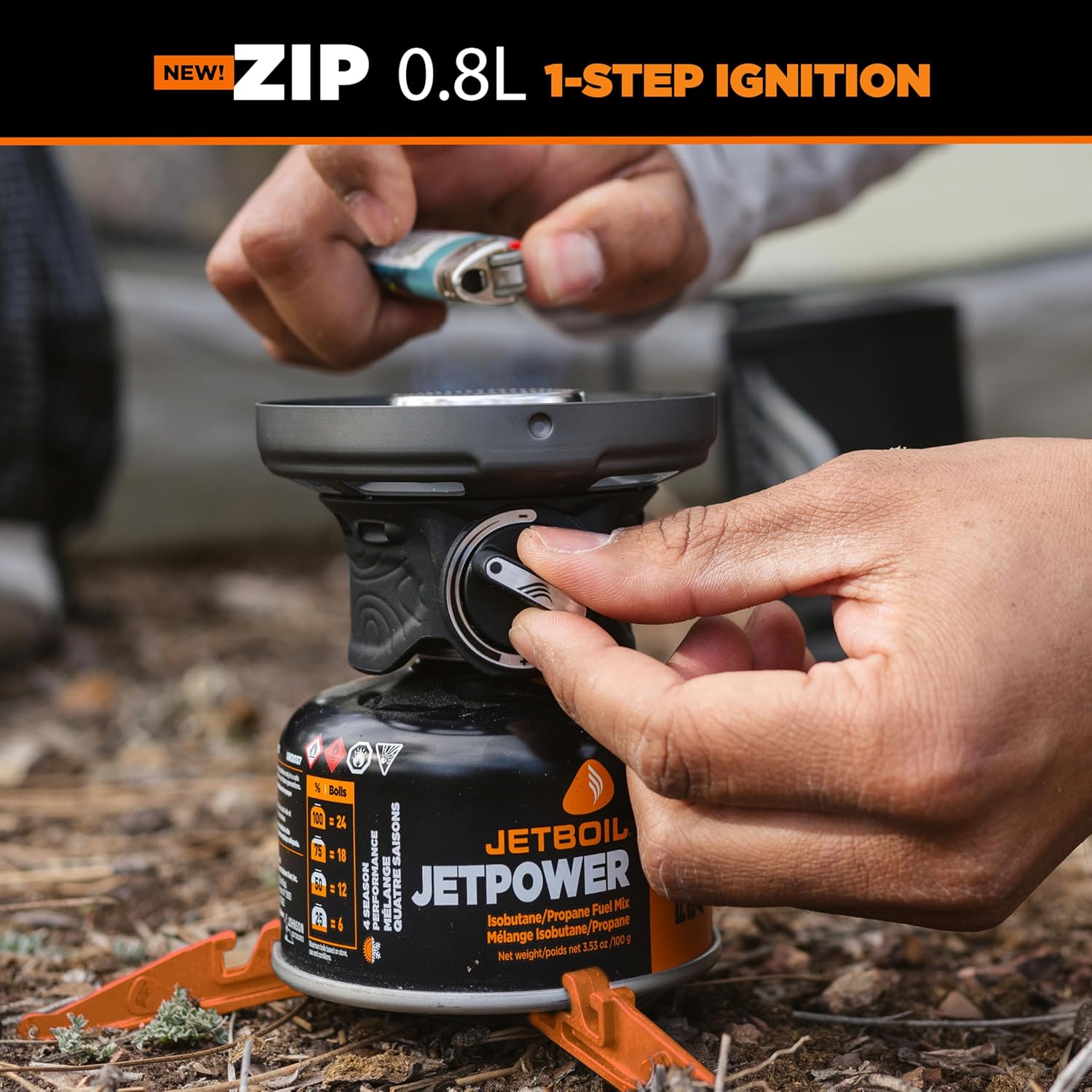 Person igniting a Jetboil Jetpower stove with a lighter outdoors.