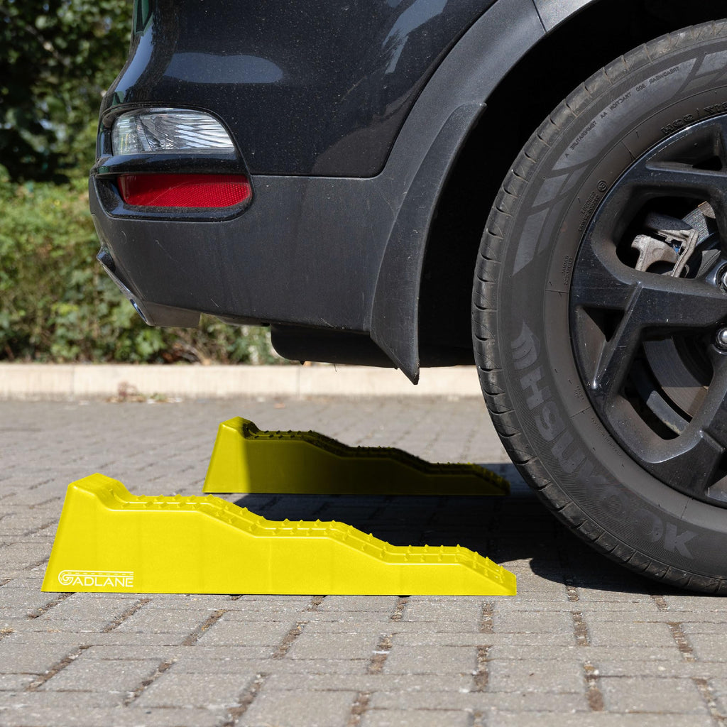 Black car with a yellow car stopper on a paved surface